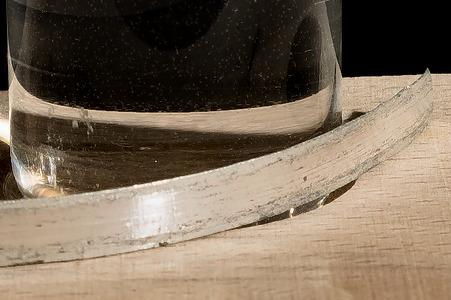 Ein Stück Magnesium neben einem Reagenzglas mit Wasser